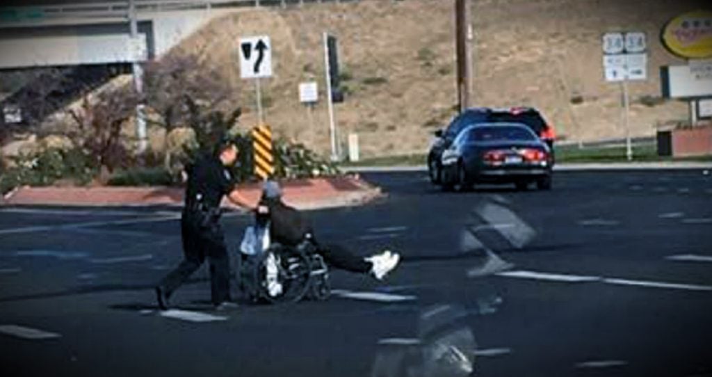 godupdates police officer pushing man in wheelchair at busy intersection fb