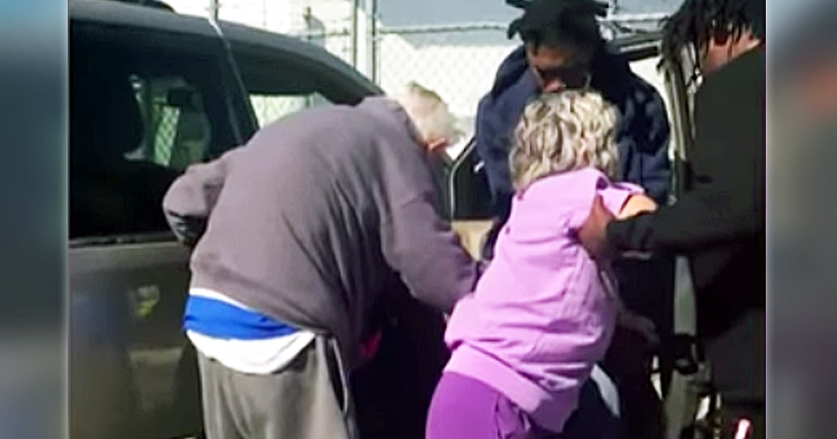 3 men helping an elderly couple at gas station