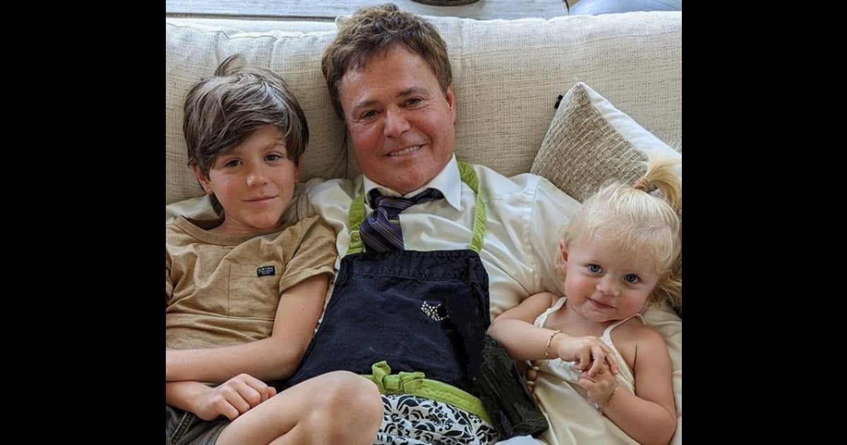 Singer Donny Osmond holds two of his grandchildren in photo