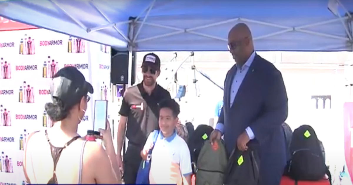 nascar driver helps kids with backpacks